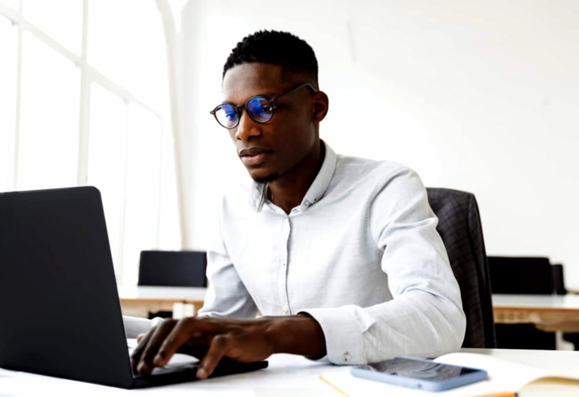 Étudiant international consultant son budget sur ordinateur dans un environnement moderne